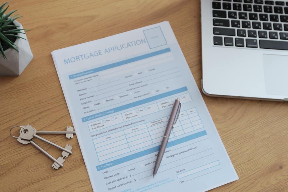 Get Pre-Approved for a Mortgage Mortgage application form on a desk next to house keys, a pen, and a laptop.