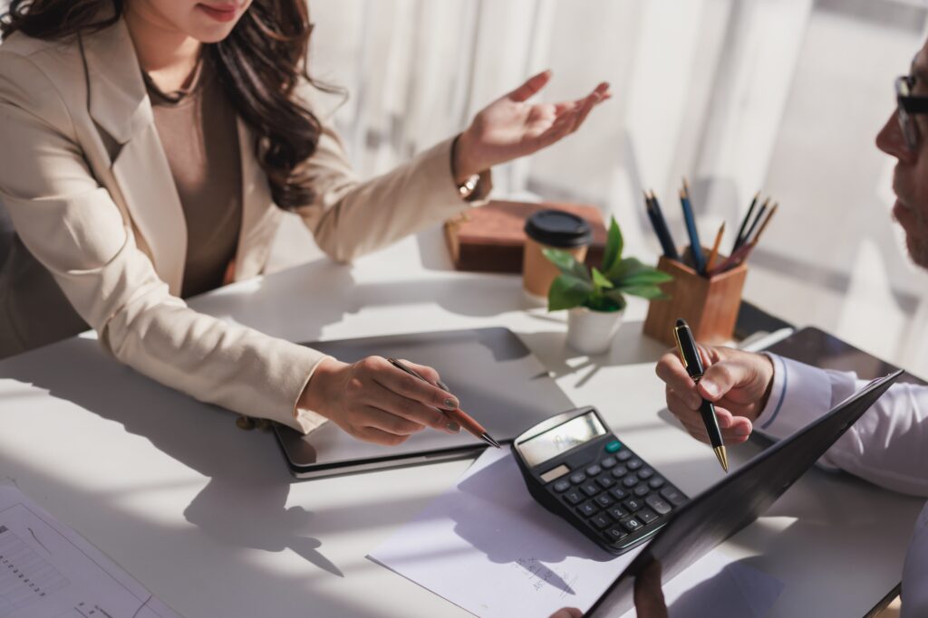 Reviewing Home Financing Numbers A real estate agent and home buyer reviewing financing numbers together at a desk with a calculator and